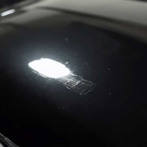 Side-by-side comparison showing the dramatic difference after Paint Protection Film installation on a vehicle hood. The protected side exhibits a deep, glossy reflection, contrasting sharply with the unprotected side, illustrating the clarity and self-healing properties of premium PPF.